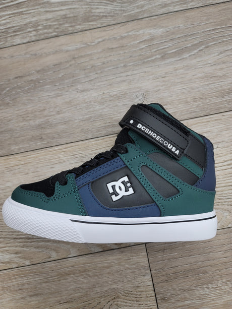 Green and blue sneaker with white sole on a wooden floor
